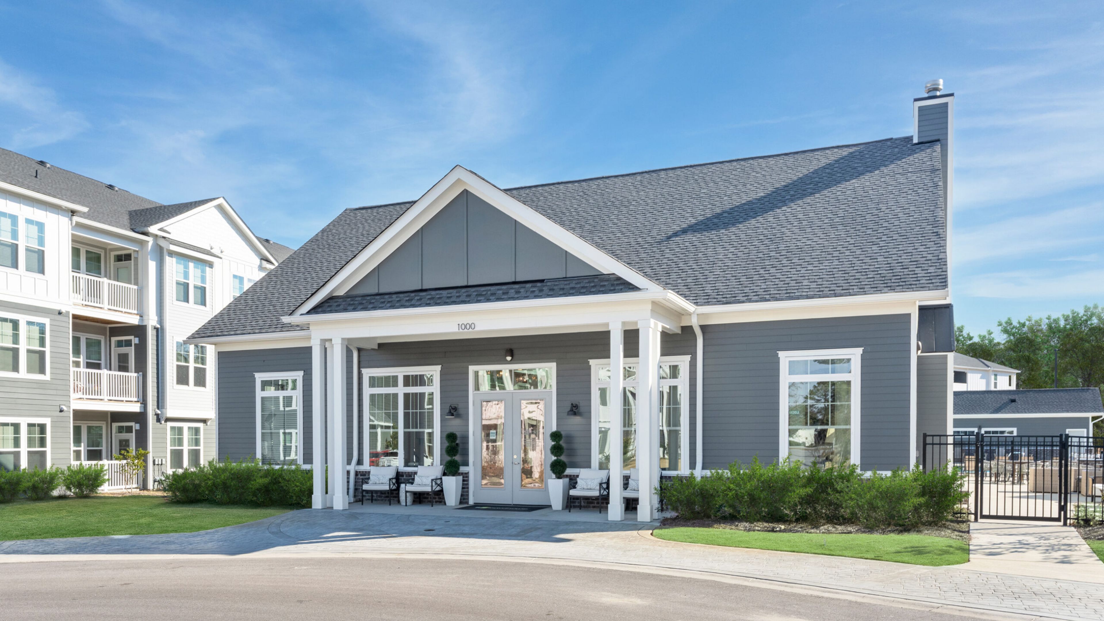 Hawthorne at New Bern waterfront with boats, modern and brick buildings, green trees, and a partly cloudy blue sky.