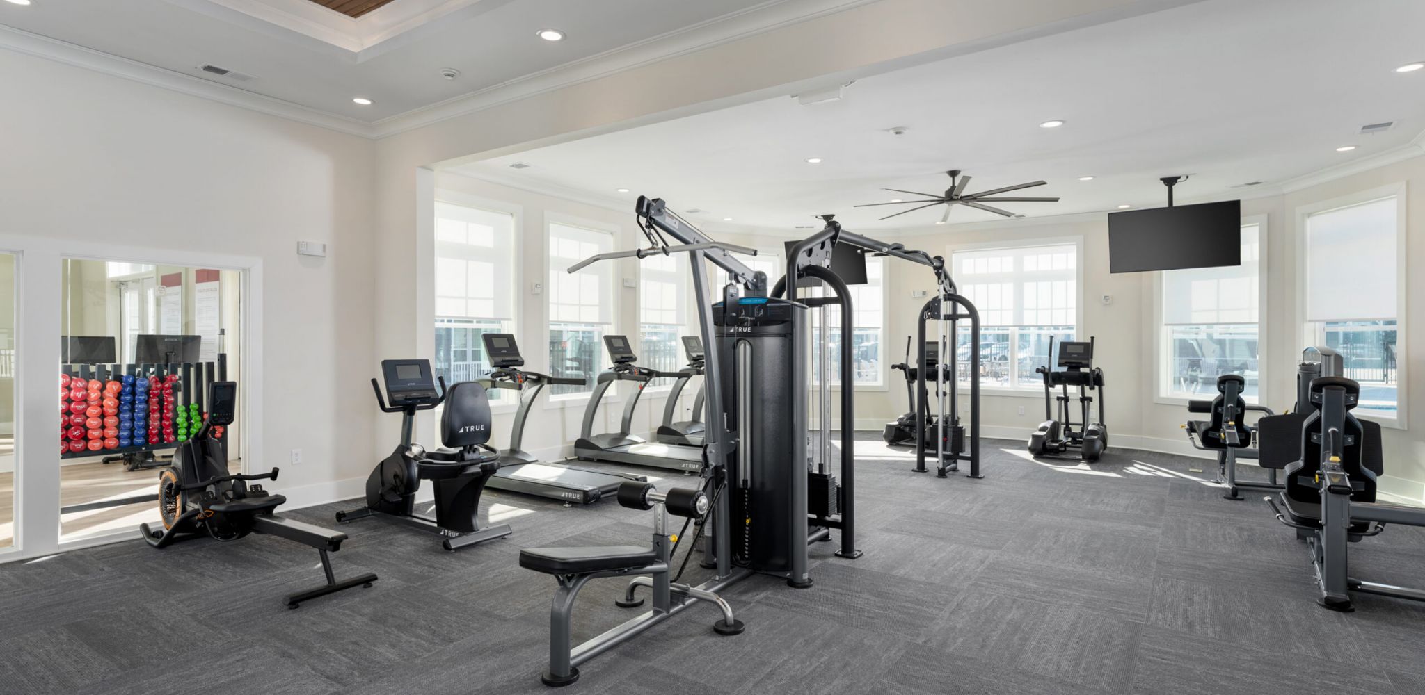 Hawthorne at New Bern modern kitchen with white cabinets, stainless steel appliances, and a granite island set for four.